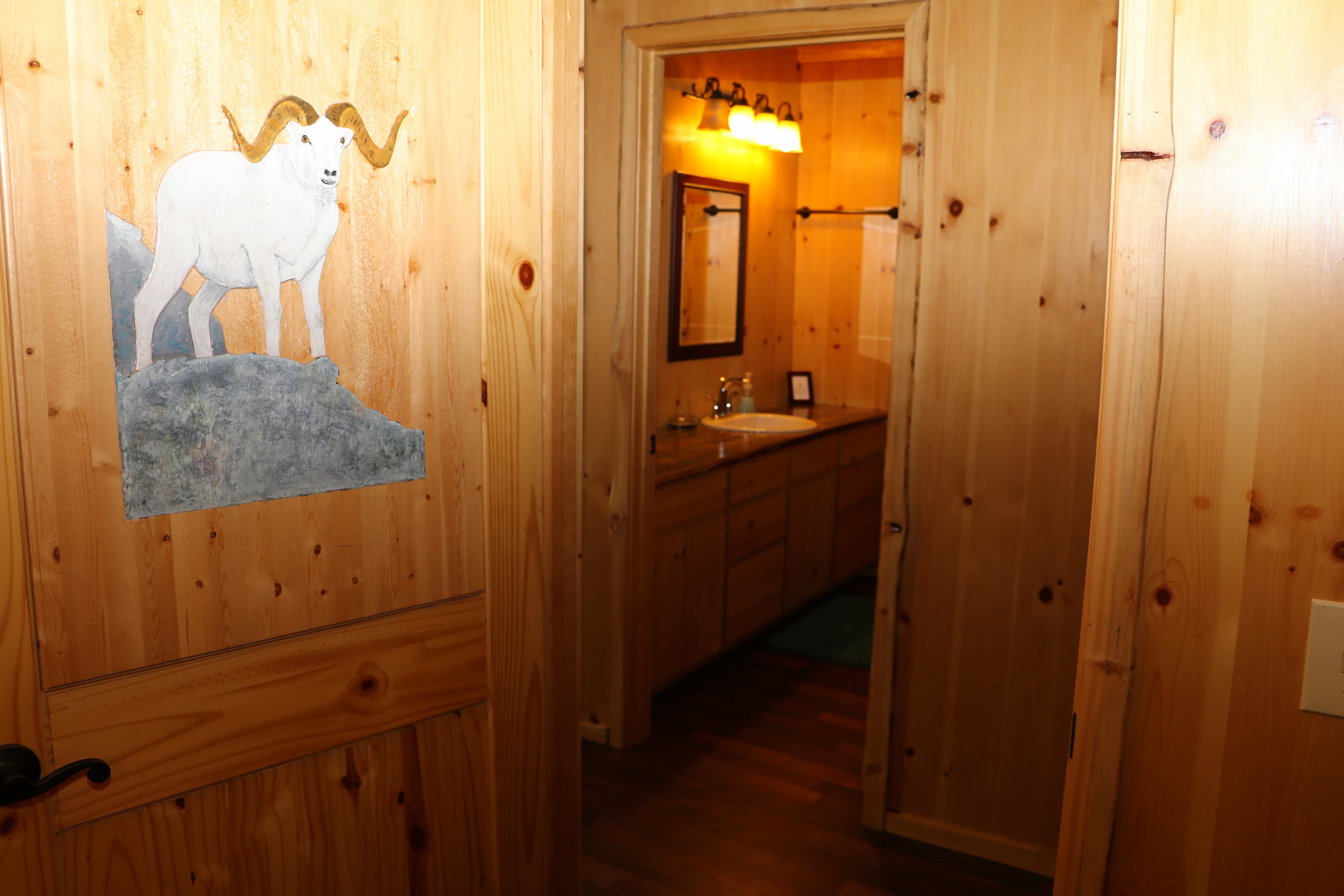 Open door, with hand-painted dall sheep, leading to first floor bath.