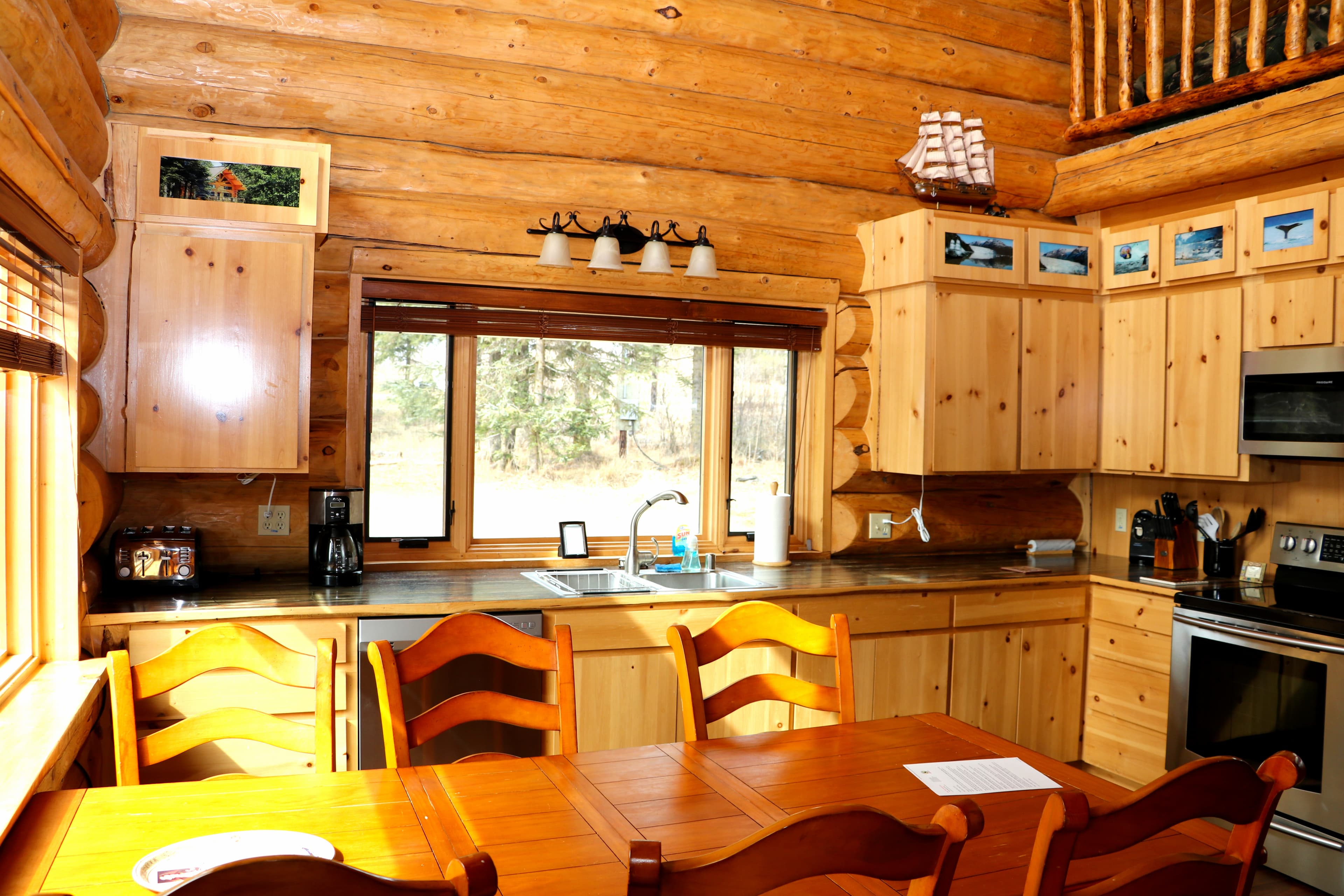 First Floor View 3 - Dining table with six chairs in foreground and full kitchen beyond.