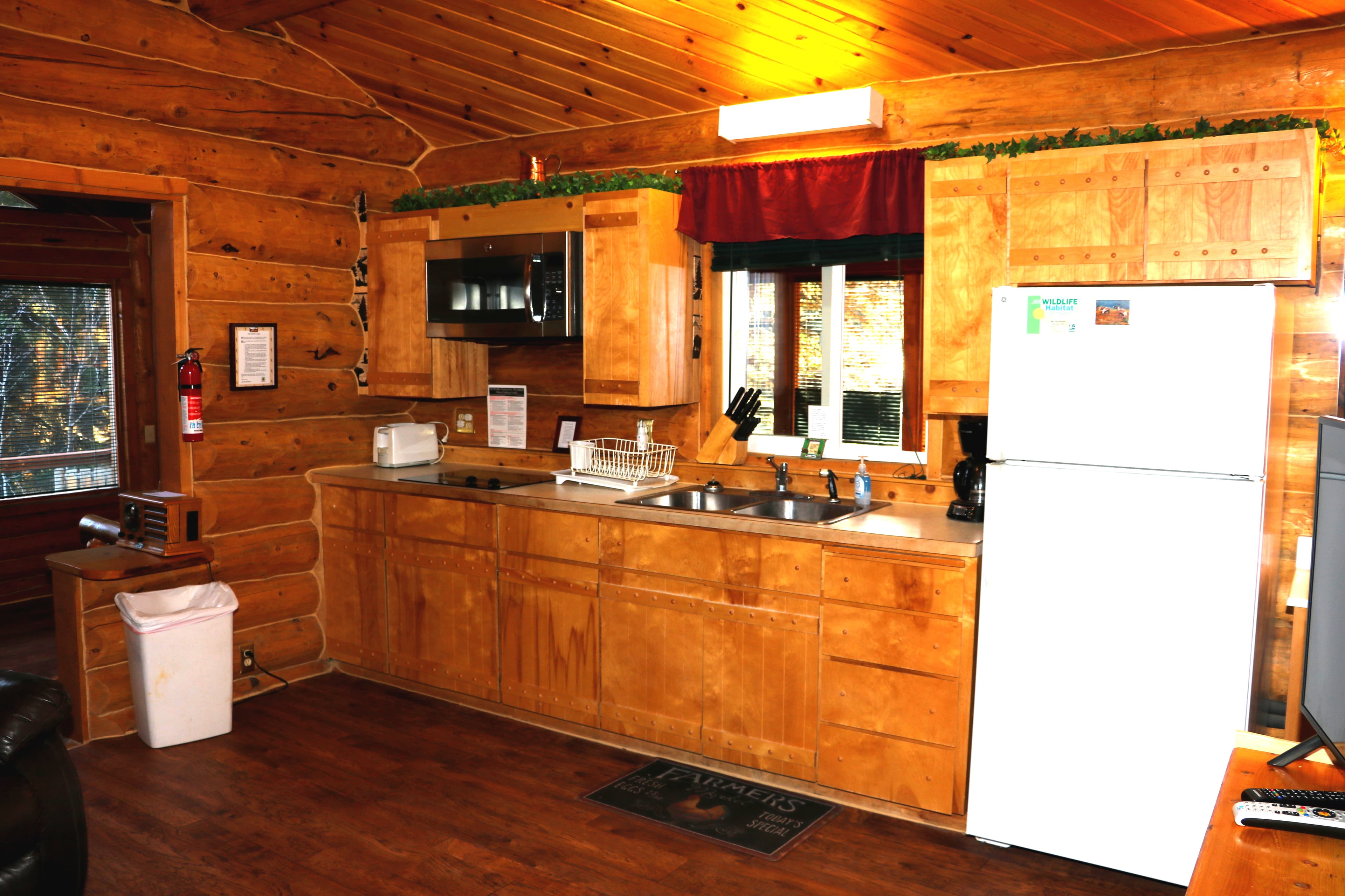 Kitchen with sink, refrigerator, microwave, coffee maker, and wooden cabinetry.